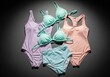 © Nyxoria - Flat lay of colorful swimwear arranged on a dark background with dramatic lighting