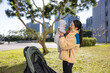 © leungchopan - Mother holding newborn baby in park under sun