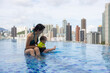 © leungchopan - Mother taking baby swimming in pool together