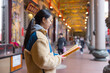 © leungchopan - Woman praying inside traditional asian temple