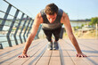 © Teodor Lazarev - Young man performing push-ups on bridge pavement