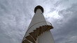 © Igor - White lighthouse with spiral staircase against cloudy sky