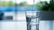 © Designer - Glass of clear water being filled on a table