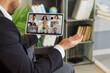 © Studio Romantic - Businessman on tablet in online conference dueing video call. Remote meeting in office shows teamwork, active communication, and discussion with colleagues. Virtual collaboration and productivity.