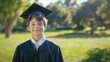 © NadeemShahzad - High angle portrait of smiling boy in graduation gown standing on grassy field at park