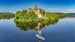 © Iuliia Sokolovska - Aerial drone view of woman paddling SUP board on beautiful Lough Key lake with McDermotts Castle on small island, stand up paddling water adventure on vacation, travel in Ireland
