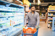 © Serhii - Man pushing shopping cart in retail store aisle