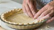© adaptable_ Lark98A1 - Hands shaping pie crust dough inside a glass pie dish on a floured surface, preparing homemade pie crust.