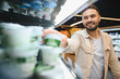 © Serhii - Man smiling selecting yogurt dairy product in supermarket