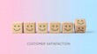 © MD NAYEM - A row of wooden blocks with smiley faces and one sad face on a pastel pink and blue background representing customer satisfaction