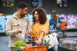 © Serhii - Couple checking long grocery receipt experiencing financial shock