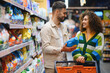 © Serhii - Happy couple shopping for laundry detergent in supermarket aisle