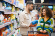 © Serhii - Couple shopping for laundry detergent in supermarket aisle