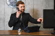 © Serhii - Hotel concierge talking on phone helping client