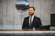© Serhii - Smiling concierge welcoming guests at hotel reception desk