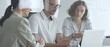 © volha_r - Business team collaborating and analyzing data on a laptop during a productive office meeting, discussing strategies and making informed decisions