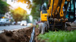 © Laura - Excavator laying fiber optic cables in a trench on grassy ground beside a city road with passing cars, defocused background, broadband internet installation concept, outdoor