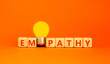 © Dzmitry - Empathy symbol. The concept word Empathy on wooden cubes. Beautiful white table. Beautiful orange background. Beautiful yellow light bulb. Copy space. Business, psychological and empathy concept.