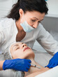 © junky_jess - Woman beautician injecting rejuvenating filler into the neck of a female patient in a beauty clinic, close-up