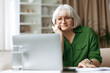 © Anastasiya - Senior woman looking at laptop screen with thoughtful expression at home. Mature caucasian female using technology for communication and online activity in relaxed retirement lifestyle