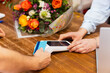 © ALIDA - Florist accepting credit card payment for bouquet of flowers