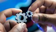 © Ahmed - Two hands holding small metal gears, demonstrating mechanical principles.