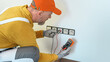 © Sabrewolf - Electrical installation. An electrician during installation a wall sockets to multi pack socket. Hands and sockets out of focus.