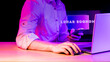 © Michael - Real photo of unrecognizable person using laptop with authentic hologram displaying 'Lunar Economy' in neon lights, no compositing