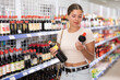 © JackF - Young woman shopper choosing soy sauce in asian goods store