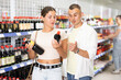 © JackF - Couple of young man and young woman shoppers choosing soy sauce in asian goods store