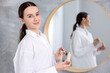 © New Africa - Woman with skin foundation indoors. Makeup product