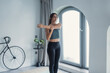 © Daniel - Woman stretching arms in modern cozy living room i, keep healthy lifestyle, improve flexibility, do acrobatics gymnastics work out at home concept
