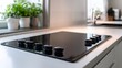 © irawan - Modern Black Glass Electric Induction Cooktop with Control Knobs.