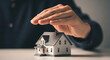 © THIBNH - Human hand sheltering a miniature residential home model representing real estate asset protection, property security, financial safety, and homeowner insurance coverage concept