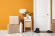© Pixel-Shot - Interior of hallway with door, table and cardboard boxes on moving day