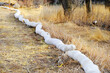 © elena.tres - Erosion control tube along grassy roadside. Flood prevention equipment.