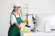 © Pixel-Shot - Female janitor cleaning desk in office