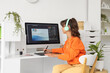 © Pixel-Shot - Female graphic designer in headphones working at home