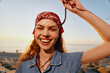 © SHOTPRIME STUDIO - smiling woman with bandana and braided hair wearing denim shirt enjoying sunny beach outdoors with warm light and joyful expression