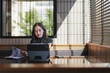 © crizzystudio - Asian woman working with tablet and documents in cafe