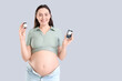 © Pixel-Shot - Young pregnant woman with glucometer on light background. Gestational diabetes concept