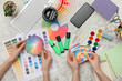 © Pixel-Shot - Female graphic designers holding color palettes on white grunge background, top view