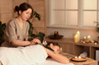 © Pixel-Shot - Beautiful Asian woman undergoing mud treatment on table in dark spa salon