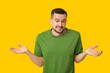 © Pixel-Shot - Handsome ashamed young man shrugging on yellow background