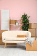 © Pixel-Shot - Cardboard boxes with sofa in living room on moving day