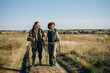 © sashafolly - Red bearded man with black girlfriend engages in Nordic walking at autumn countryside