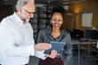 © Westend61 - Business colleagues collaborating and smiling with tablet in modern office
