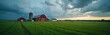 © Vadym - Red barn and silo stand on green grass field. White farmhouse nearby under cloudy sky. Rural american landscape panorama, tranquil countryside scene, peaceful farm life.