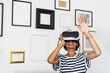 © Westend61 - Young woman with VR glasses at home