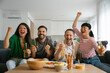 © Westend61 - Friends celebrating football match at home with drinks and snacks